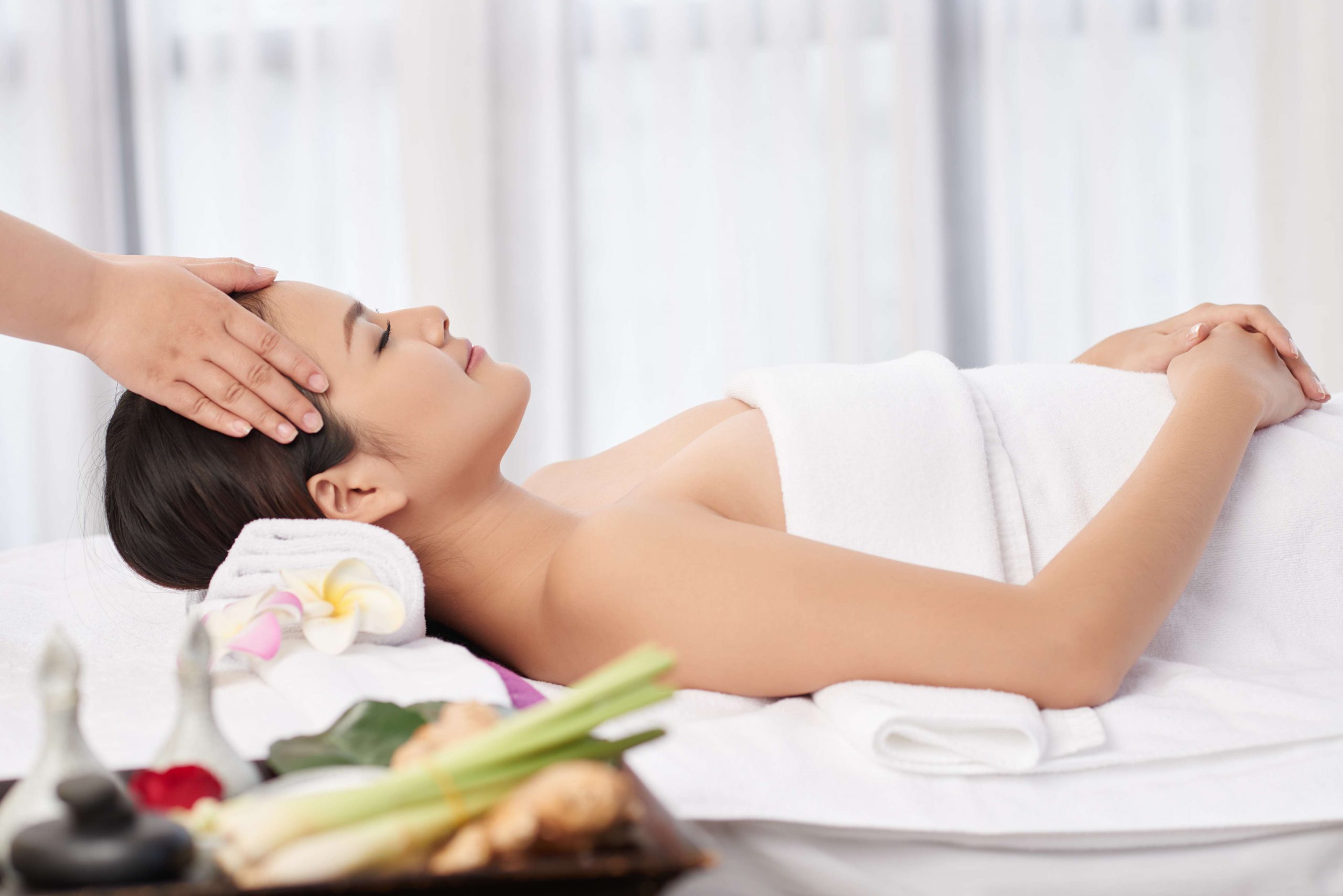 Smiling pretty young woman getting relaxing head massage